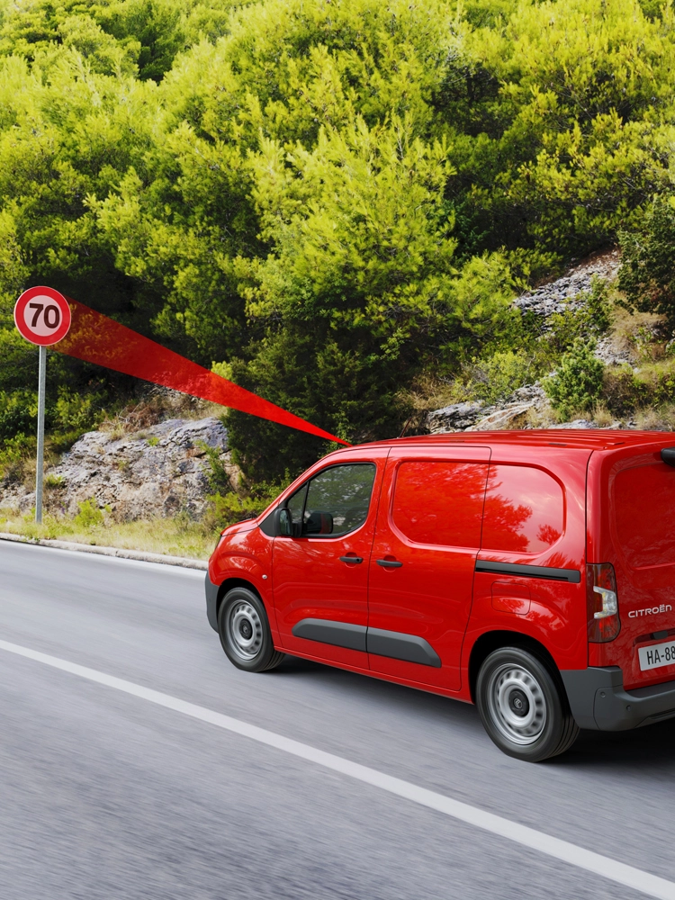 Berlingo sur une route de campagne affichant les limitations de vitesse et la vitesse recommandée.